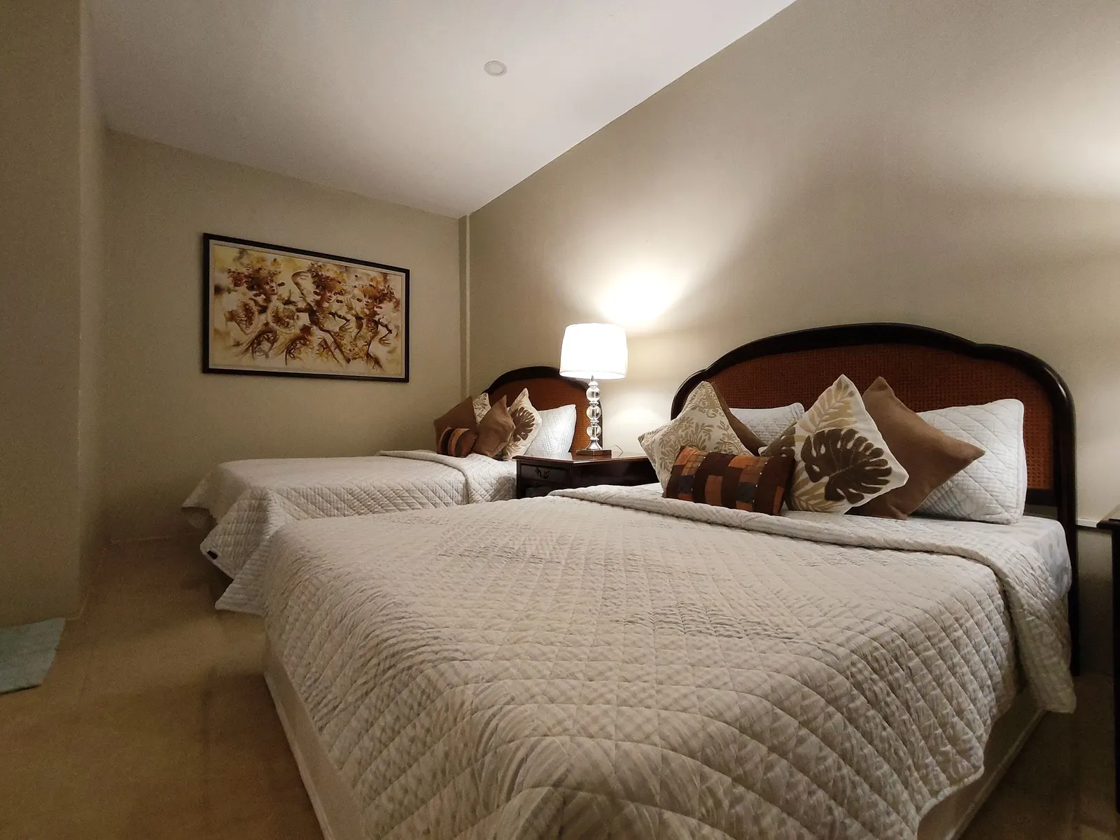A queen bedroom with a framed Balinese painting