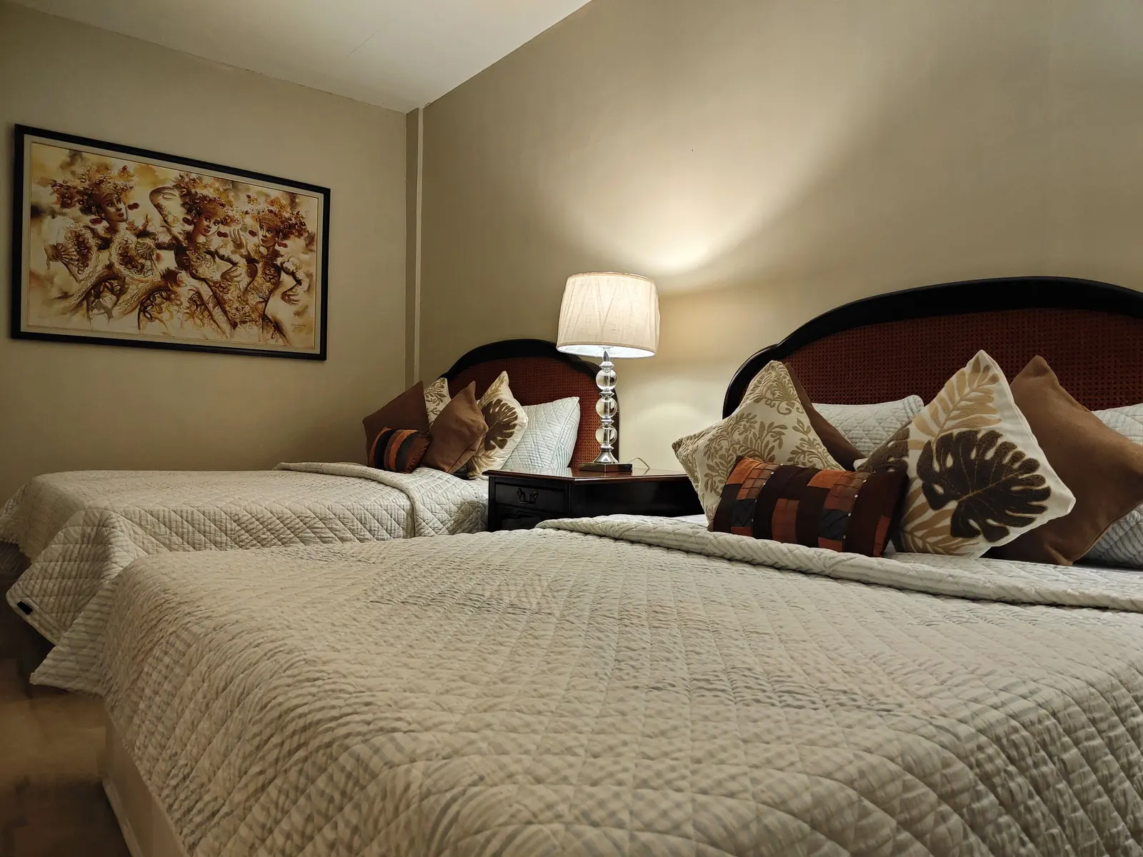An air-conditioned bedroom with two beds and lamps