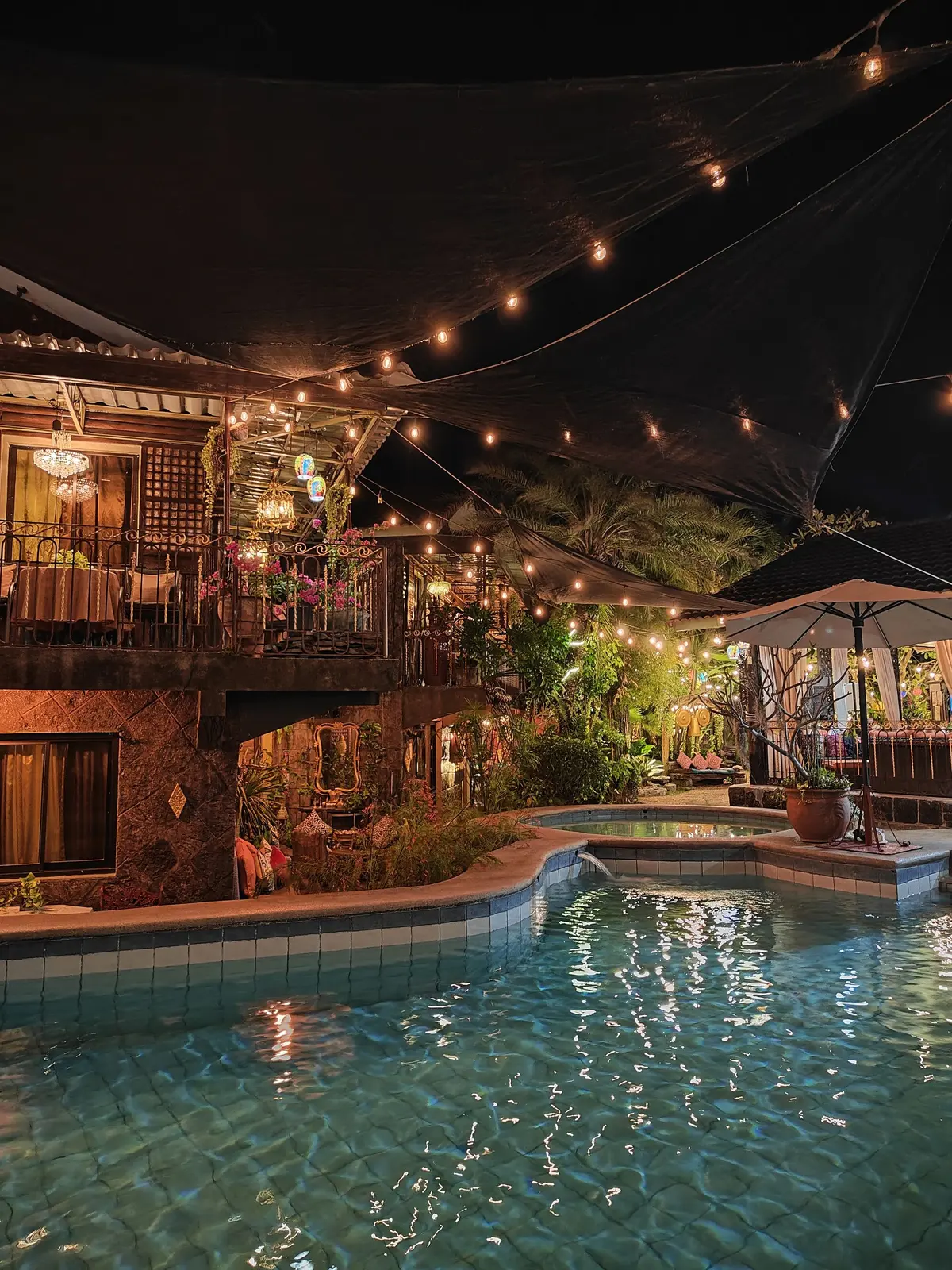The pool and cabin at night from the garden